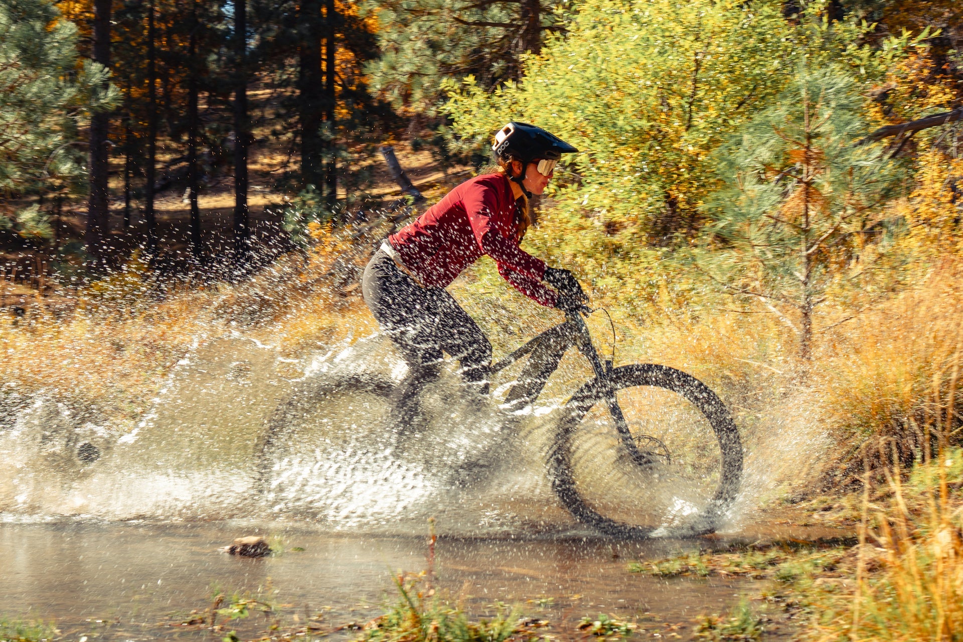 A woman riding her Aventon Ramblas ebike through a puddle